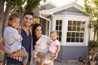 Portrait Of Latino Family Standing Outside Home