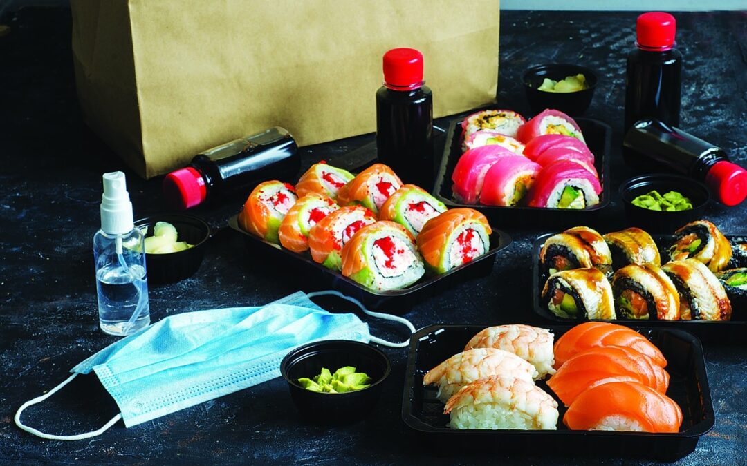 Quarantine food delivery. Set of traditional japanese food on a dark background. Sushi rolls, nigiri, raw salmon steak, rice, cream cheese, avocado, pickled ginger. Asian food frame.