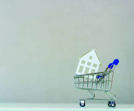 close up front view on house's model inside the shopping cart with copy space background for loan banking , home for sale and insurance concept