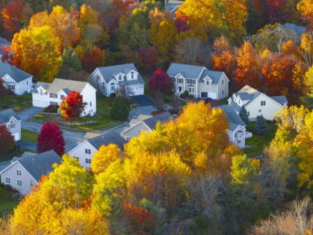 Aerial view of suburban housing community in autumn season with colorful trees
